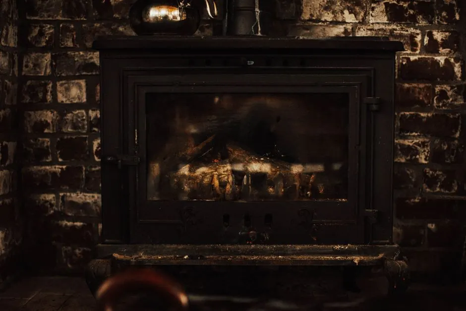 A warm and inviting vintage fireplace against a rustic brick wall, perfect for cozy winter settings.