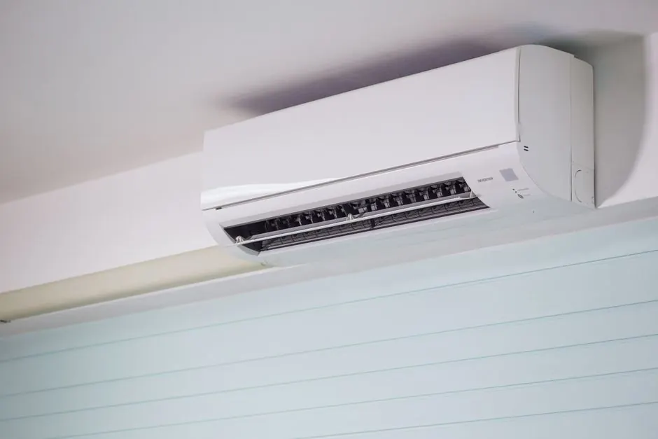 Close-up of a wall-mounted air conditioner indoors, showcasing sleek design for modern cooling solutions.