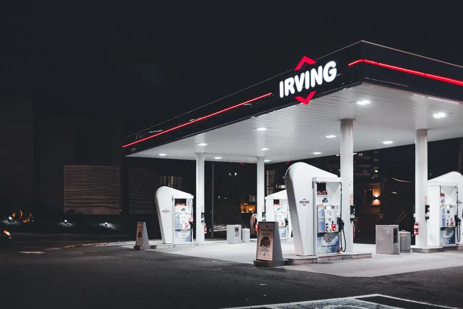 Illuminated Irving gas station at night, showcasing modern design and bright lighting.